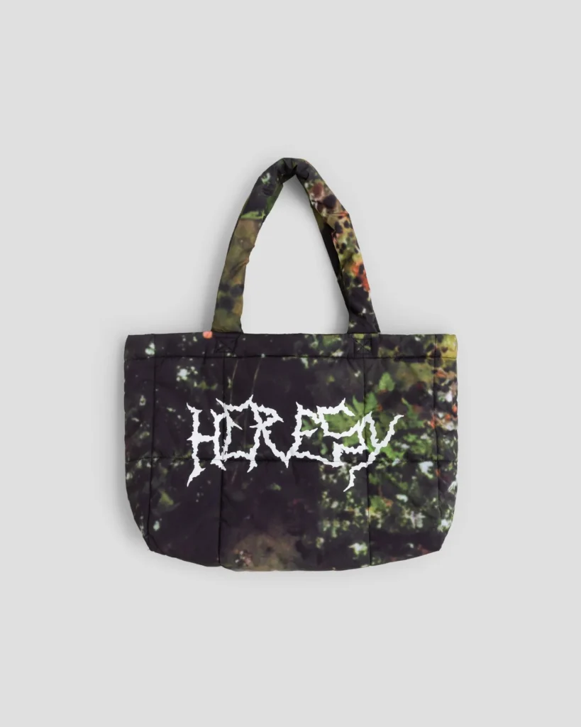 Padded black tote bag with green and brown forest print, matching handles, and white jagged lettering on the front against