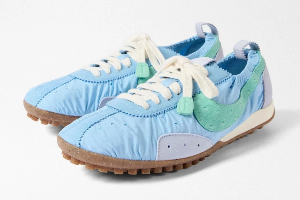 Pair of light blue Nike sneakers with mint-green swooshes, cream laces, and brown textured soles on a white background