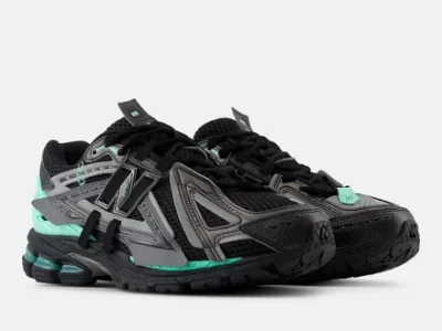 Pair of black and gray New Balance 1906A sneakers with mint green accents on a white background