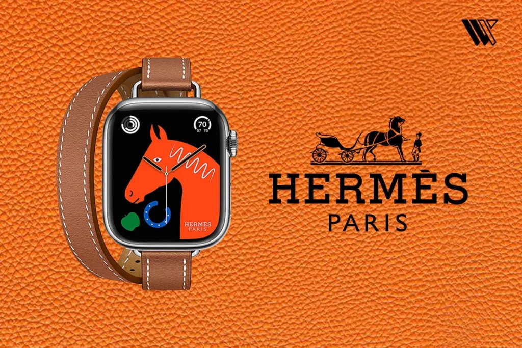 Hermès Apple Watch with brown leather double-wrap band, orange horse face, and silver case on orange textured leather