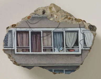Fragment of a painted building facade showing a row of curtained windows, exposed stone, and dangling black wires