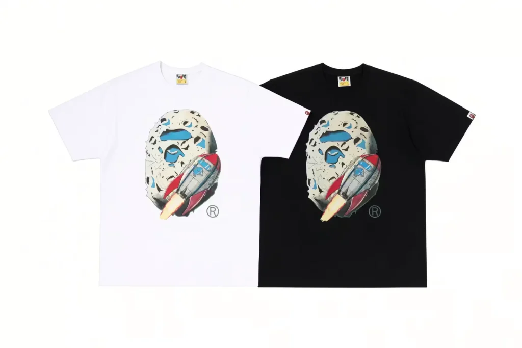 White and black T-shirts featuring a hockey mask and rocket graphic, displayed side by side on a white background