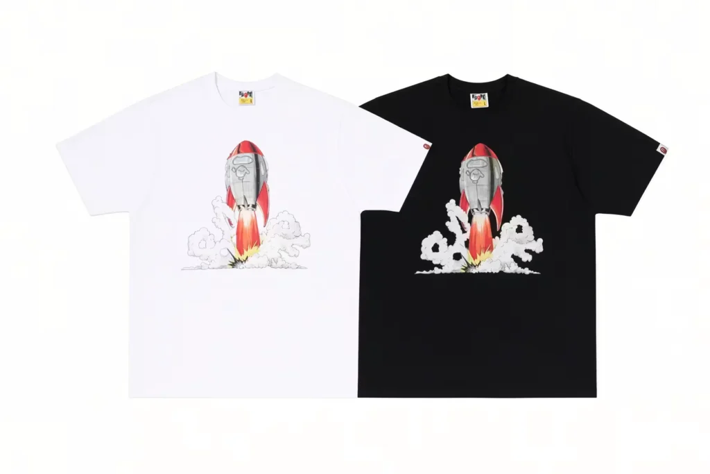 White and black T-shirts featuring a red-and-gray rocket launching through clouds, arranged on a white background