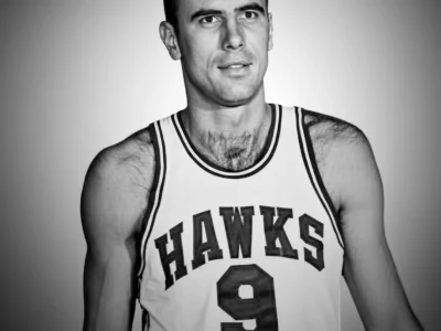 Black-and-white portrait of Bob Pettit wearing a Hawks basketball jersey with number 9 against a plain background