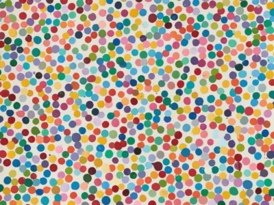 White background covered with hundreds of multicolored circular dots in varied sizes and scatter arrangement