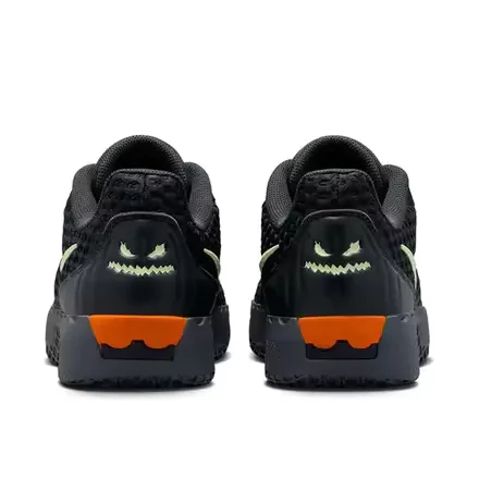 Pair of black shoe viewed from the heel, featuring glowing monster faces and orange sole accents on a white background