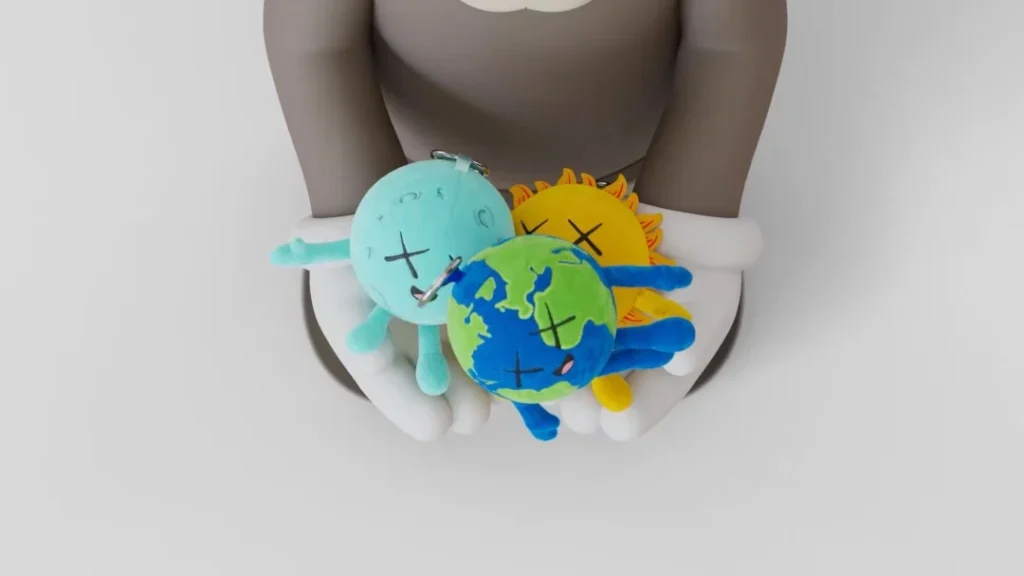 Top-down view of a person holding three colorful plush figures, including a globe-patterned blue and green character with