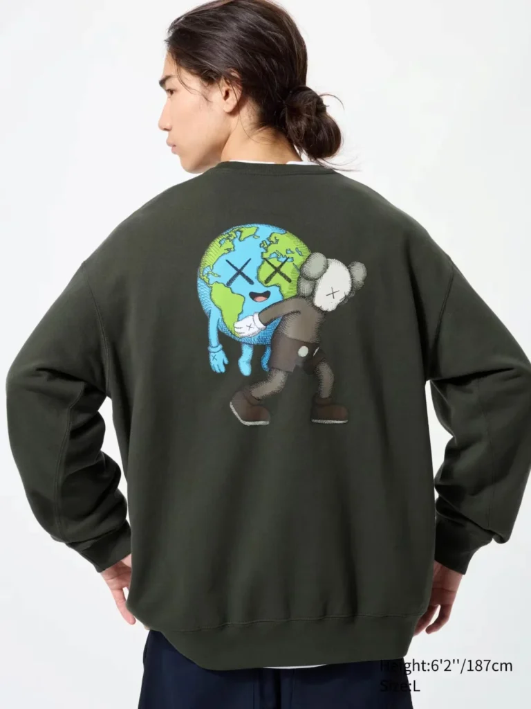 Model view from behind wear a dark green sweatshirt with a colorful globe and KAWS character graphic on the back