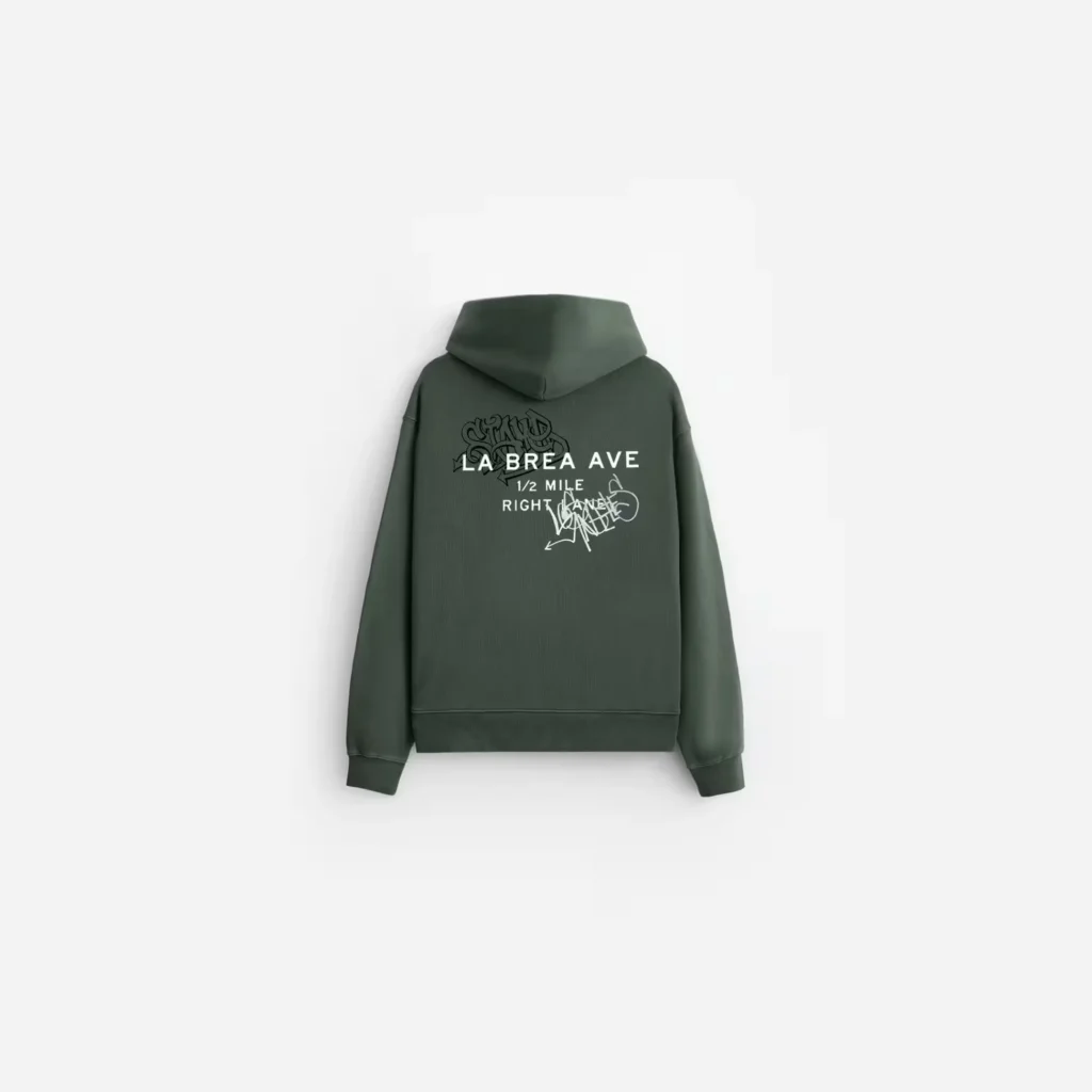 Dark green hooded sweatshirt shown from the back on white, with white “LA BREA AVE” lettering and graffiti-style graphics
