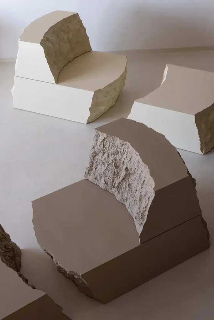 Several Lapis chairs, stools and benches arranged together in pale stone-like finishes.