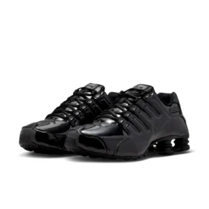 Pair of black Nike Shox shoe with glossy panels, layered laces, and visible heel cushioning on a white background