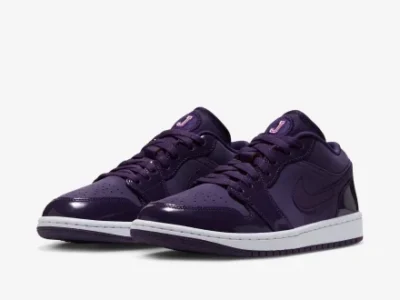 Pair of low-top sneakers in dark purple with perforated toes, swoosh logos, and white midsoles on a white background