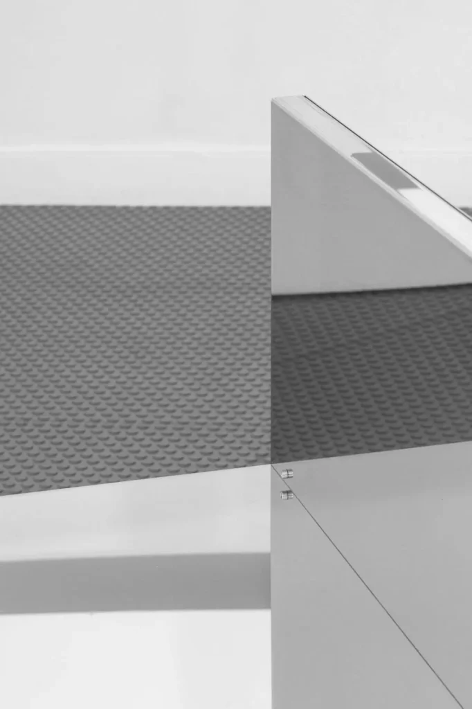 Abstract grayscale composition of intersecting geometric panels, including a textured dark surface and slanted white