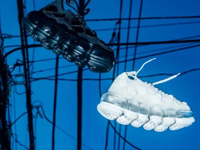 Black and white futuristic sneakers float against a vivid blue background crisscrossed by black wires
