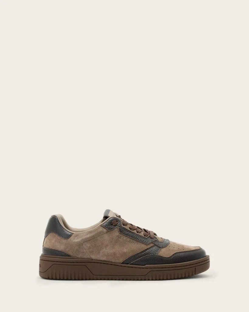 Brown suede and black leather low-top sneaker with matching brown sole, shown in side profile against an off-white background