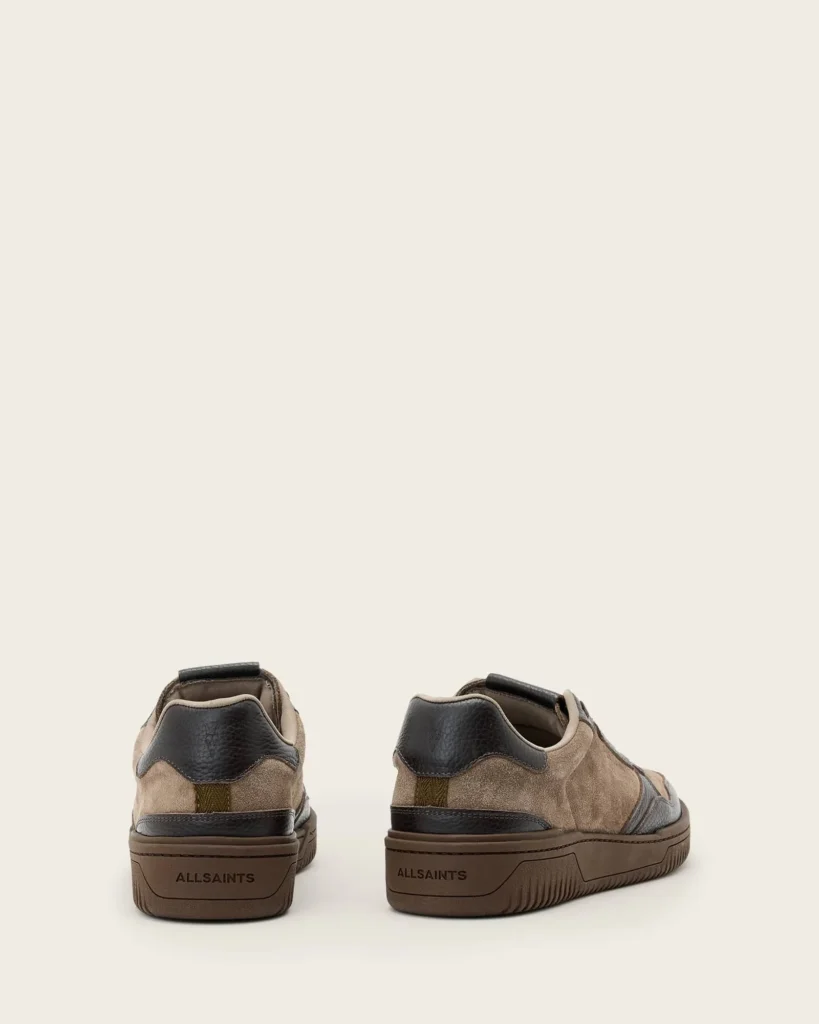 Pair of brown suede and black leather sneakers shown from the rear and side on a plain beige background