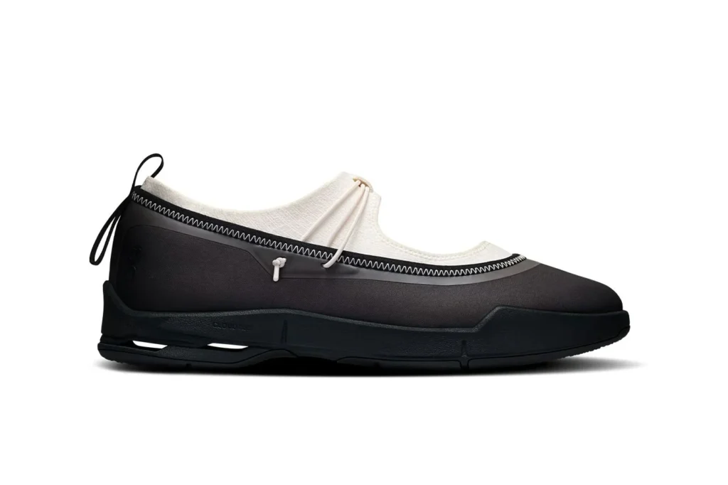 Black and white slip-on sneaker with zigzag stitching, pull loops, and a sculpted black sole on a white background