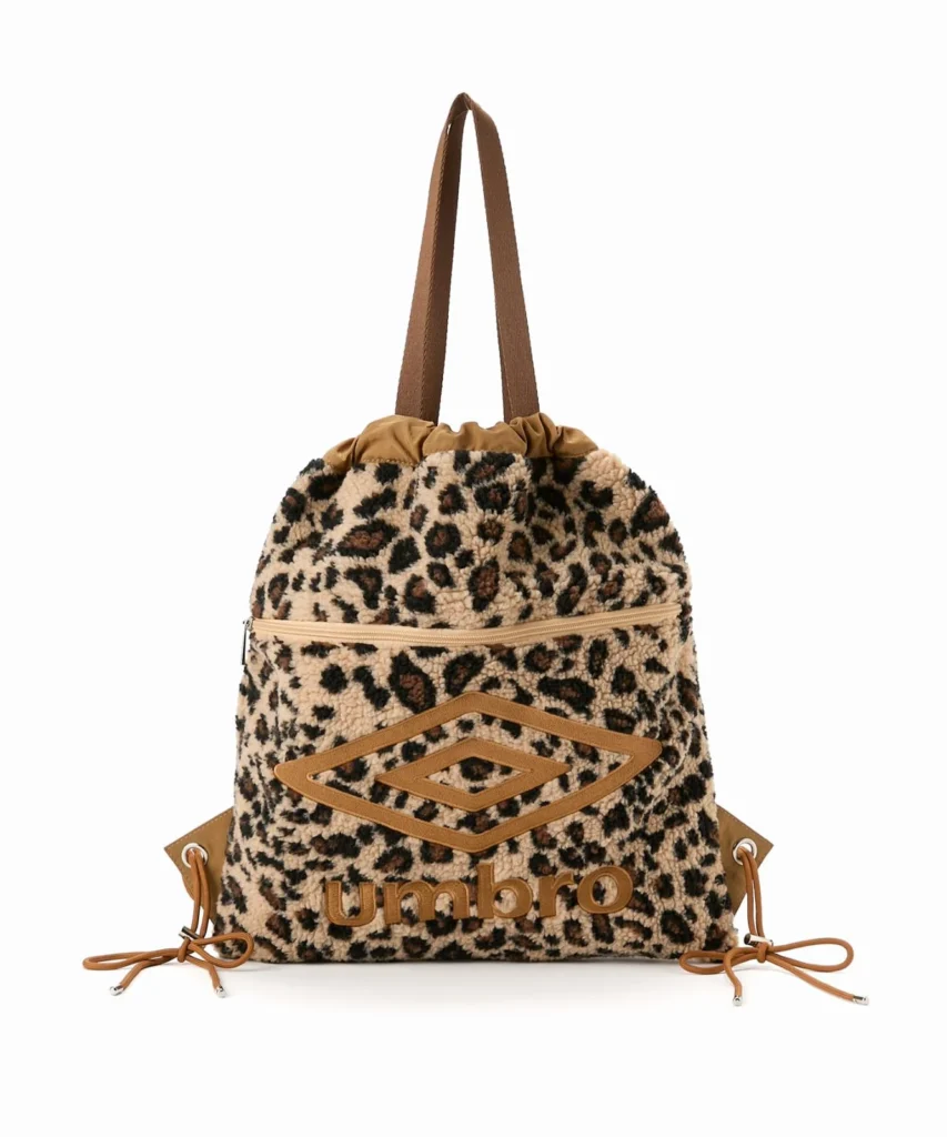 Leopard-print sherpa Umbro backpack with tan straps, drawstring sides and a raised double-diamond logo on white background