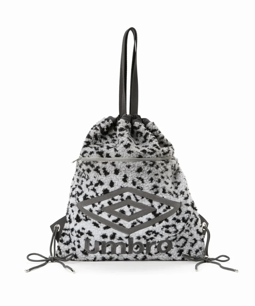 Black-and-white fluffy Umbro drawstring backpack with a zip pocket, double diamond logo and long shoulder straps on white