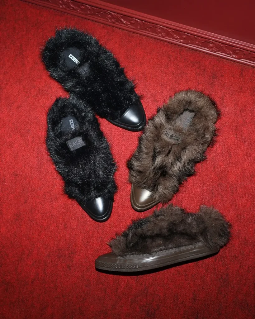 Four furry slippers—two black and two brown—arranged on a red carpet-patterned surface