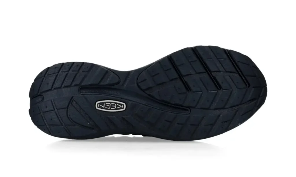 Bottom view of a black KEEN shoe showing its textured rubber outsole and tread pattern