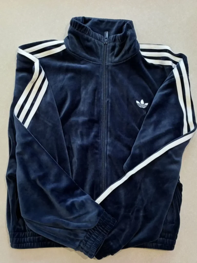 Navy Adidas zip-up track jacket with white triple stripes on sleeves and trefoil logo