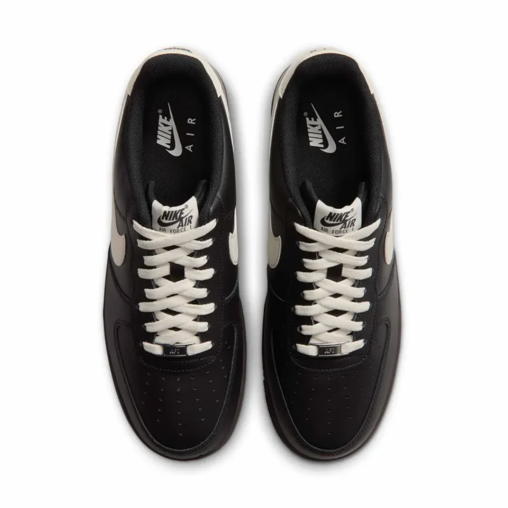 Pair of black Nike Air Force 1 sneakers with white laces and swooshes, viewed from above on a white background
