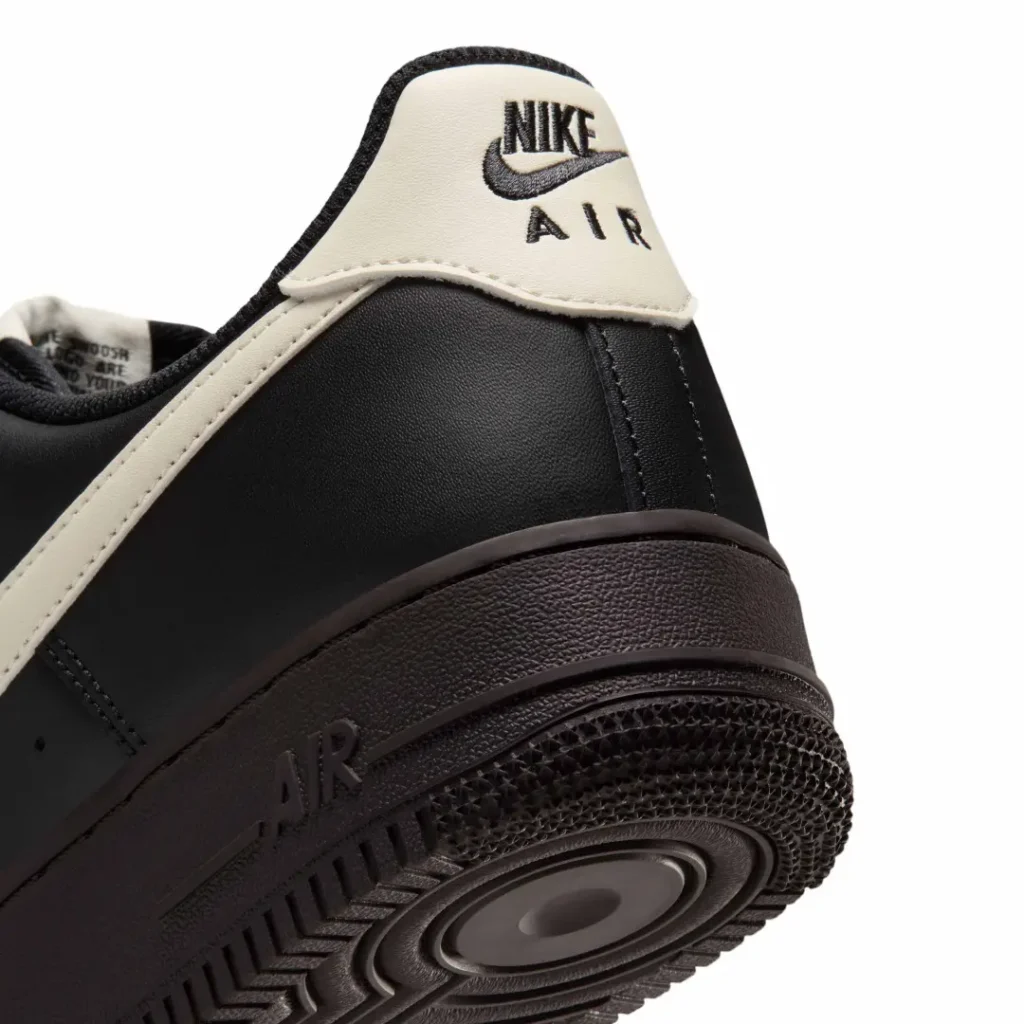 Close-up of a black Nike Air sneaker heel with cream trim, embossed Air branding, and textured rubber sole on white