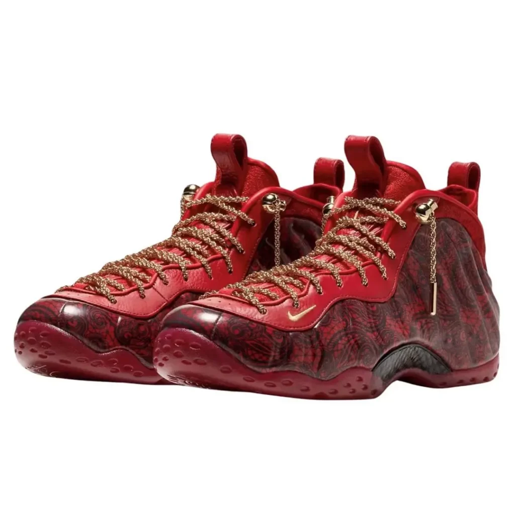 Pair of red high-top sneakers with gold chain laces, patterned dark red panels and textured rubber soles on white background