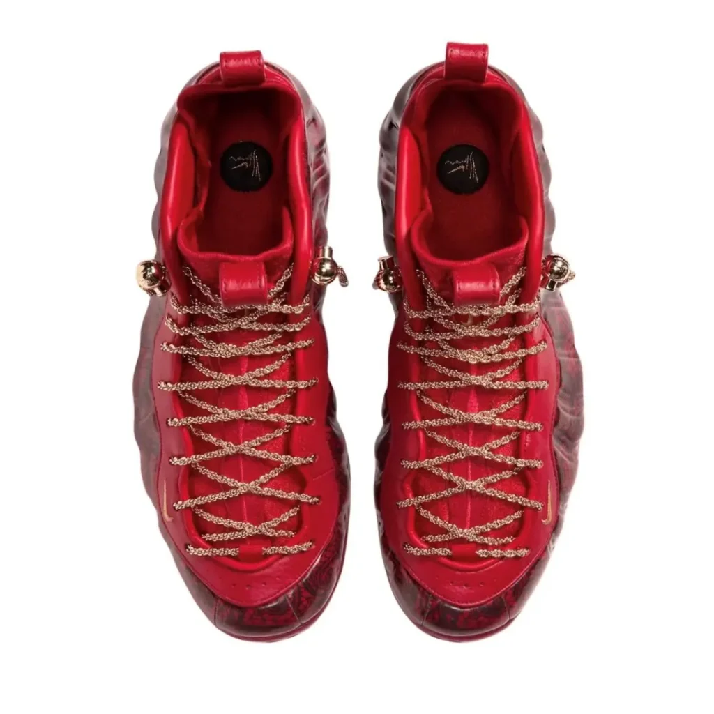 Pair of red high-top sneakers with gold chain laces and translucent patterned soles, viewed from above on white background