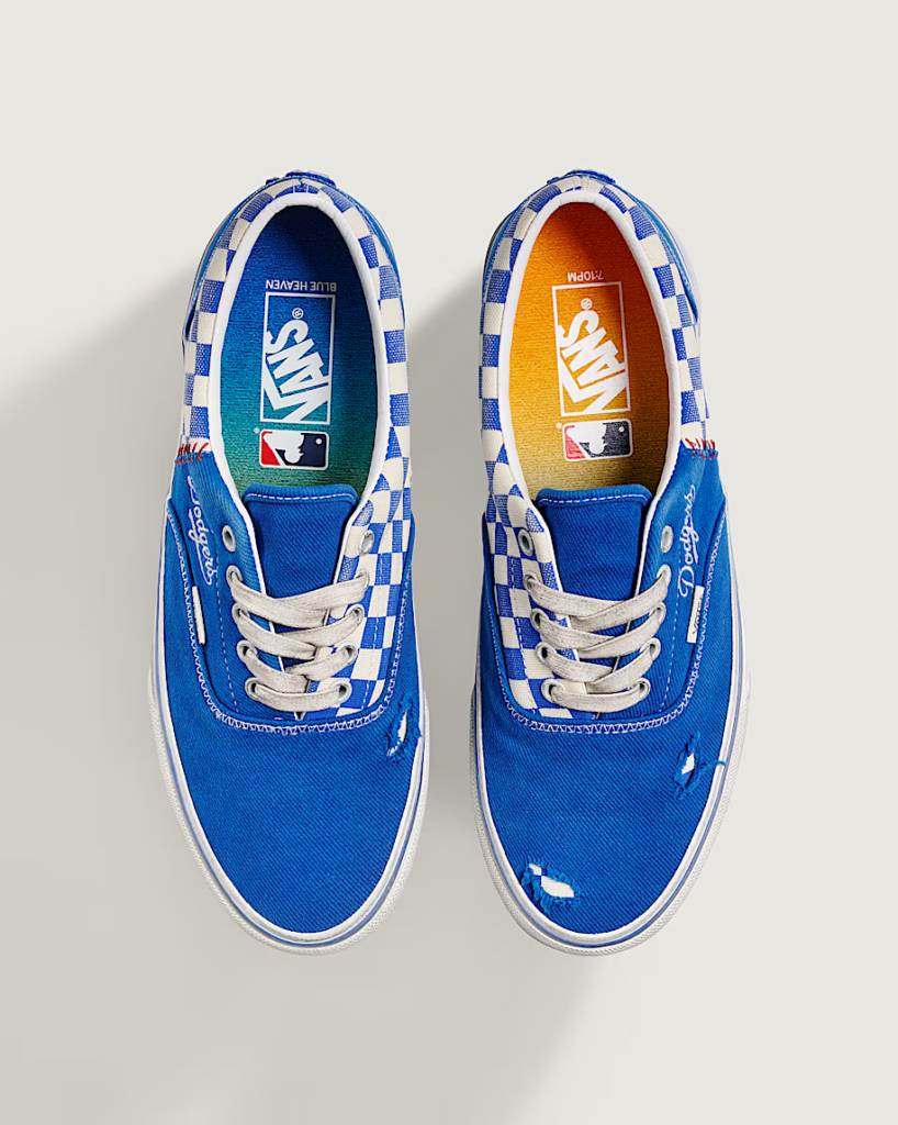 Pair of blue Vans sneakers with white laces, checkerboard trim, and Dodgers and MLB logos on the insoles