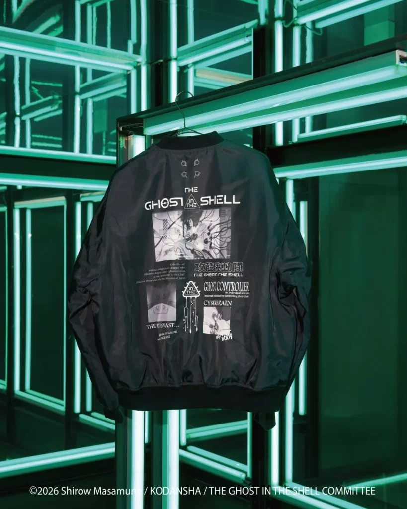 Black bomber jacket with “The Ghost in the Shell” graphics hanging against glowing green mirrored panels
