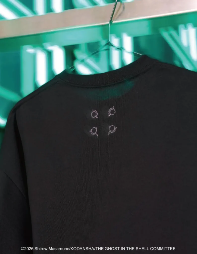 Black T-shirt on a hanger with four small outlined symbols on the upper back, against a teal graphic backdrop