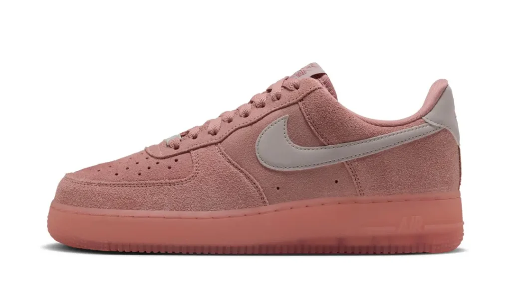 Pink Nike low-top sneaker with a gray swoosh on a white background