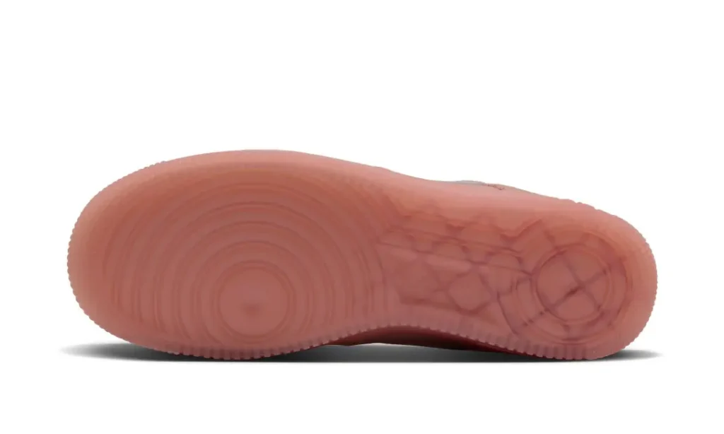 Translucent pink rubber sneaker sole with concentric circular tread patterns, shown in profile against a white background