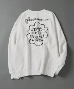 White crewneck sweatshirt with black Tokyo Soulset 1995 graphic and cloud motif, laid flat on a gray background