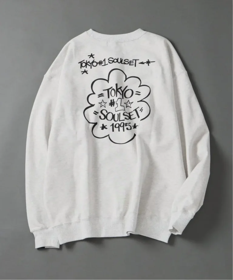 White crewneck sweatshirt with black Tokyo Soulset 1995 graphic and cloud motif, laid flat on a gray background
