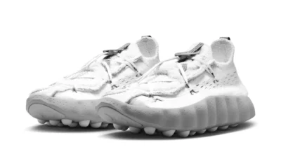 Pair of white knit shoe with thick sculpted soles and rounded segmented outsoles on a white background