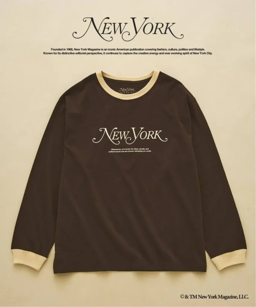 Brown long-sleeve New York Magazine shirt with cream collar and cuffs, laid flat on a beige background