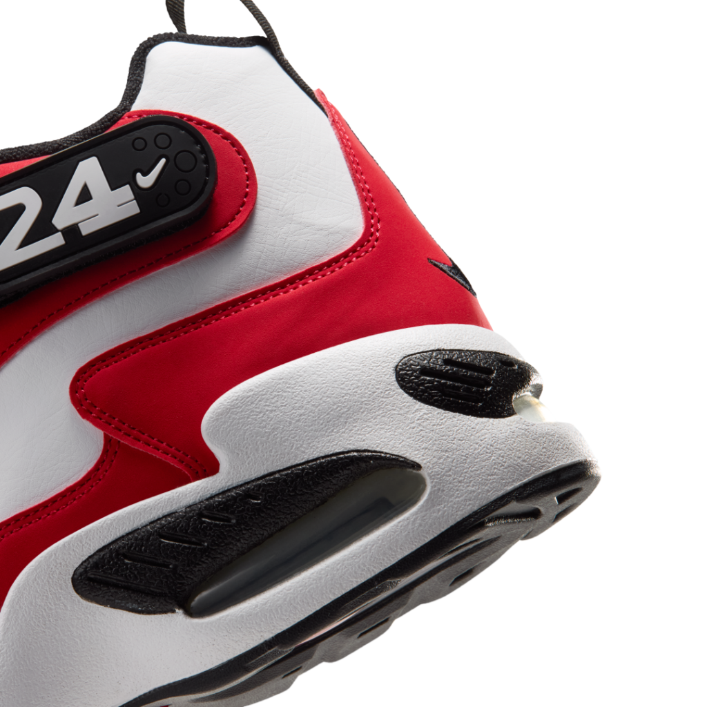 Close-up of a red, white and black high-top sneaker showing its textured sole and visible air cushioning against white