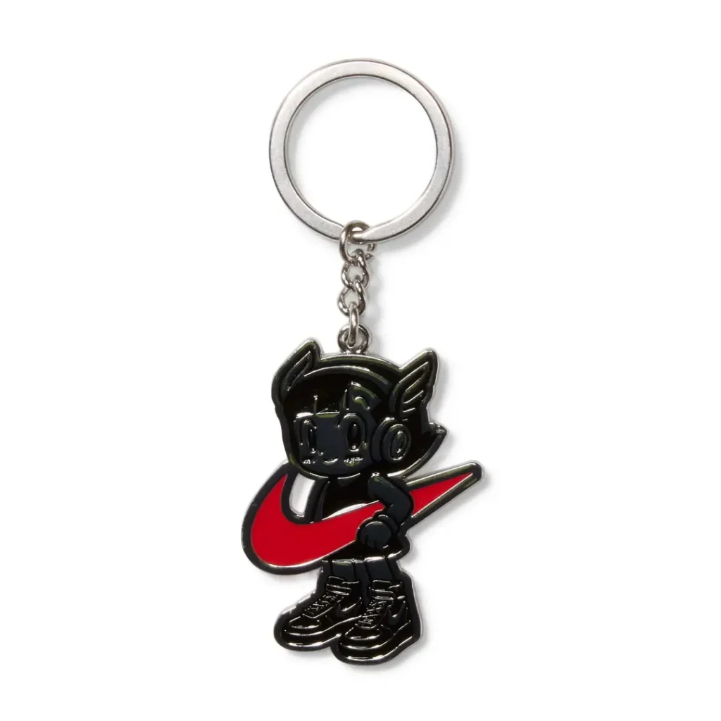 Black metal keychain with a cartoon character holding a red Nike swoosh, wearing black sneakers, on a white background