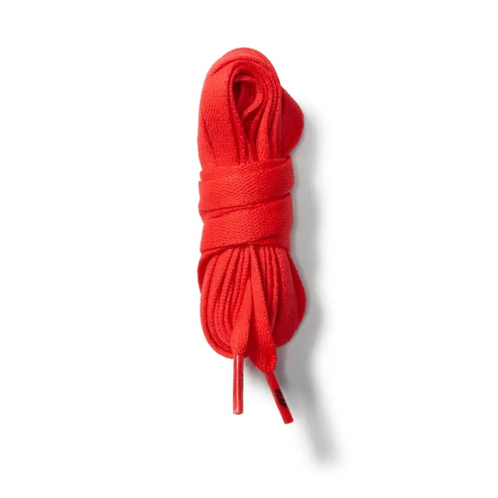 Bright red shoelaces bundled and tied against a white background, with two ends hanging down