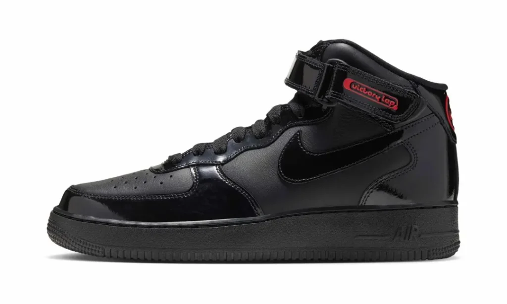 Black patent leather Nike Air Force 1 Mid sneaker with a red Victory Lap Radio label, shown in profile on white background