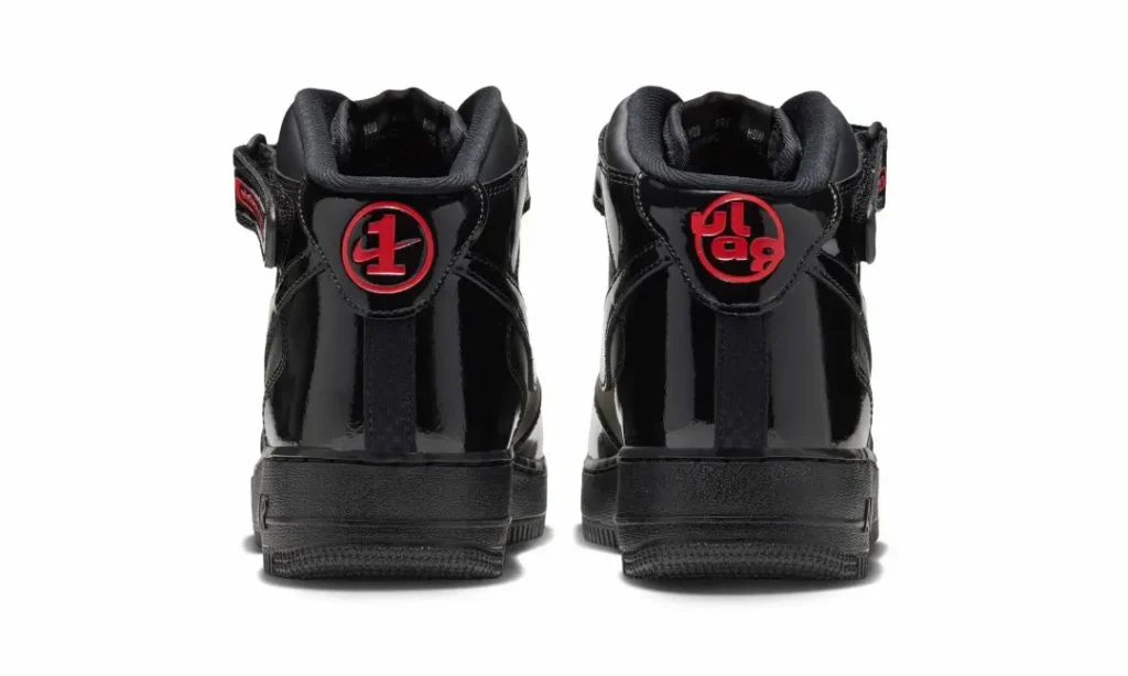 Rear view of two black patent leather Nike Air Force 1 Mid sneakers with red circular logos on white background