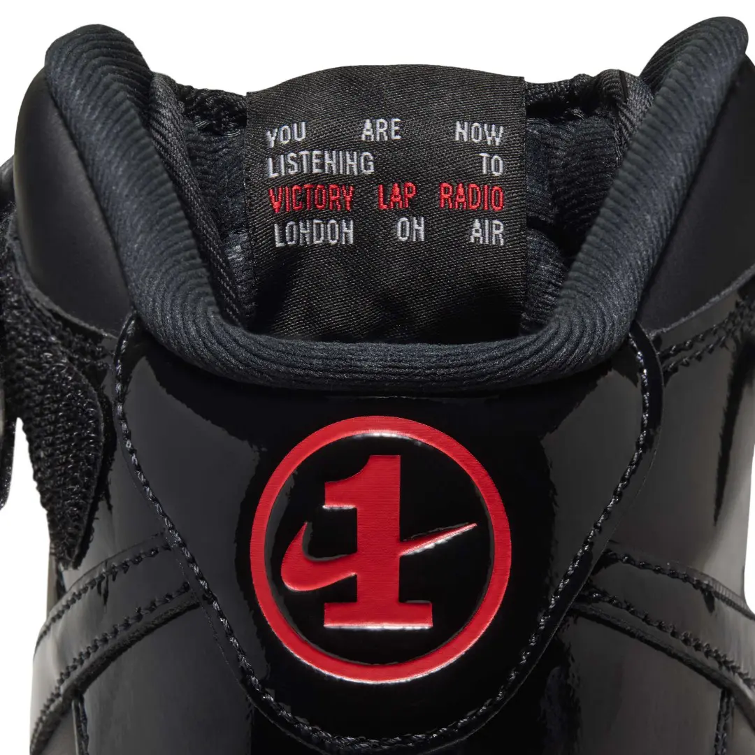 Close-up of a black patent Nike Air Force 1 Mid tongue with red logo and “Victory Lap Radio” label