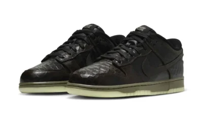 Pair of black low-top sneakers with perforated toe boxes and pale green translucent soles against a white background