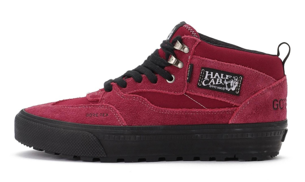 Red suede mid-top sneaker with black laces, thick black sole, silver eyelets and Half Cab side label on white background