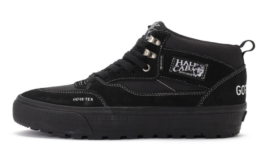 Black high-top Vans shoe with Gore-Tex branding, metal eyelets, thick lugged sole, and Half Cab side label on white