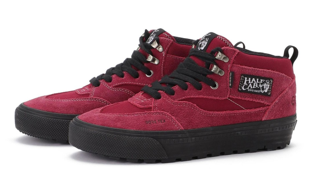 Pair of burgundy high-top shoe with black laces, textured soles, and Half Cab branding on a white background