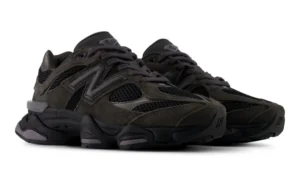 Pair of black New Balance 9060 sneakers with mesh panels, suede overlays, chunky soles, and gray accents on a white